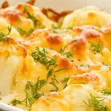 Coliflor al horno gratinada con queso y hierbas frescas. Un plato reconfortante y delicioso.