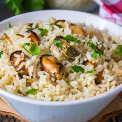 Un tazón de arroz con mejillones y perejil picado. Un plato delicioso y fácil de preparar.