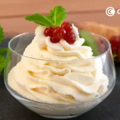 Deliciosa nata montada en copa, coronada con grosellas rojas y menta. Perfecta para cualquier postre.