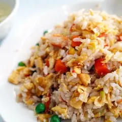 Arroz tres delicias con trozos de huevo, zanahoria y guisantes. Un plato delicioso y colorido.