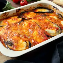 Bandeja de berenjenas a la parmesana recién horneadas, con queso derretido y salsa de tomate burbujeante.