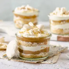 Postre en vaso con capas de galleta, crema y dulce de leche. Un toque de polvito uruguayo corona esta delicia.