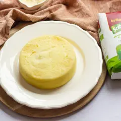 Pastel de arroz dorado y esponjoso en plato blanco, junto a un paquete de arroz Sabroz.