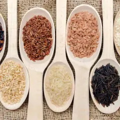 Cucharas de madera con distintos tipos de arroz, listos para cocer. Arroz negro, integral, rojo y blanco.