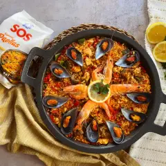 Paella mixta con gambas, mejillones y arroz dorado, lista para disfrutar.