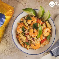 Delicioso arroz con langostinos, zanahoria, guisantes y pimiento rojo, decorado con lima y perejil. ¡Un plato para chuparse los dedos!