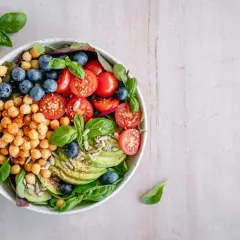 Deliciosa ensalada de legumbres con garbanzos, arándanos, tomates cherry, aguacate y semillas.