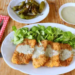 Escalopines al cabrales crujientes, servidos con ensalada verde y pimientos de Padrón.