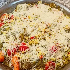 Arroz a la milanesa listo para hornear, con verduras y abundante queso rallado.