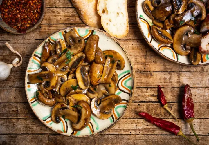 Plato de setas a la plancha con ajo, pan y guindillas secas. Un delicioso aperitivo rústico.