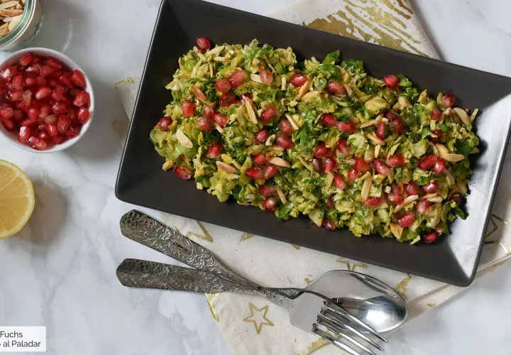 Ensalada de col con granada y almendras laminadas, un plato fresco y vibrante.