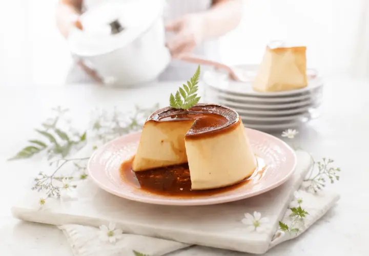 Delicioso flan de queso con caramelo líquido, decorado con una ramita verde.