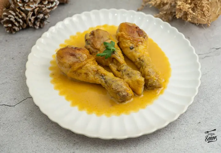 Tres jamoncitos de pollo en una cremosa salsa amarilla, decorados con perejil. ¡Un plato casero delicioso!