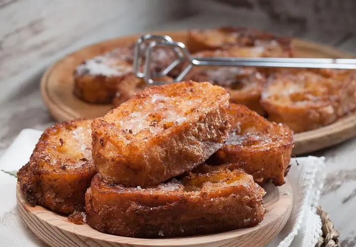 Torrijas caseras, doradas y espolvoreadas con azúcar. Una deliciosa receta tradicional.