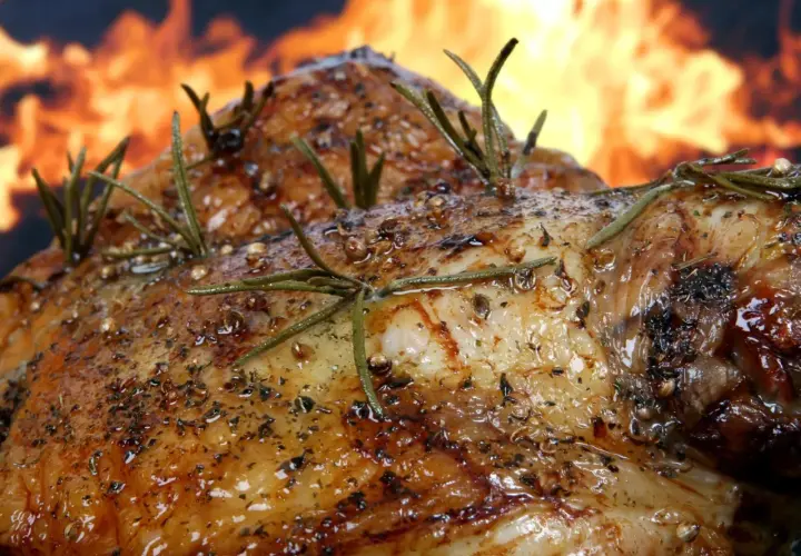 Pierna de cordero al horno, dorada y jugosa, con romero fresco y especias, lista para ser disfrutada.