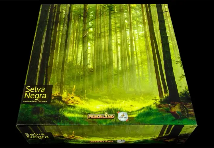 Una caja de juego con arte de bosque denso y soleado, titulada "Selva Negra". Un pavo real se asoma entre la hierba.