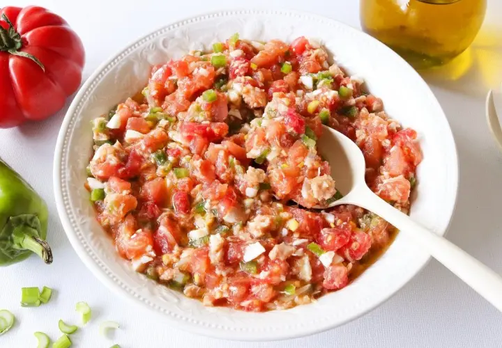Un plato de pipirrana de Jaén, una ensalada fresca de tomate, pimiento y huevo, lista para disfrutar.