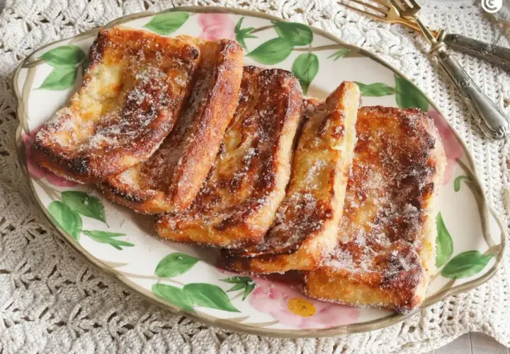 Torrijas doradas y crujientes, espolvoreadas con azúcar, recién salidas de la freidora de aire. ¡Un placer casero!