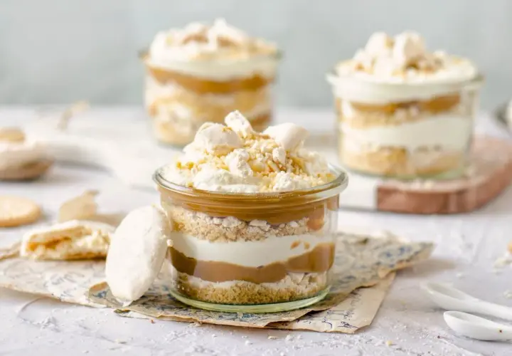Postre en vaso con capas de galleta, crema y dulce de leche. Un toque de polvito uruguayo corona esta delicia.
