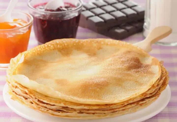 Una pila de crepes doradas, listas para disfrutar con mermelada de frutos rojos, albaricoque y chocolate. ¡Una deliciosa receta crepes!