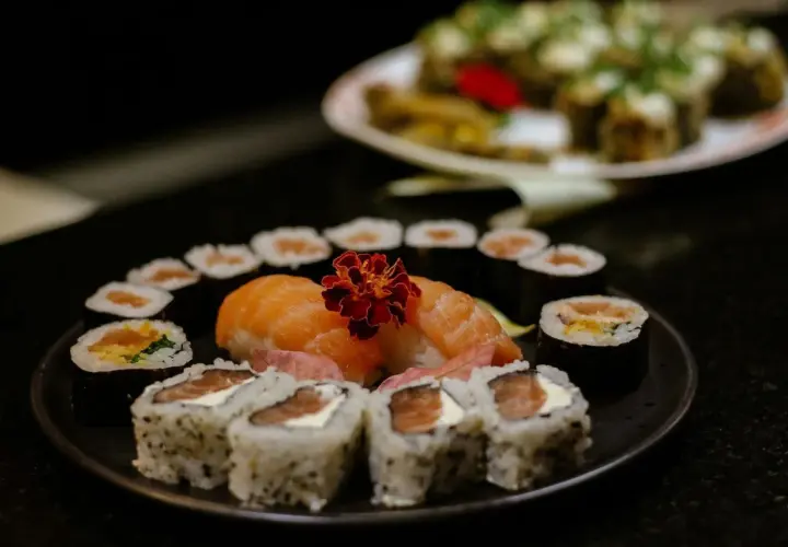 Delicioso arroz sushi receta con salmón fresco y flor decorativa. Un festín visual y culinario.