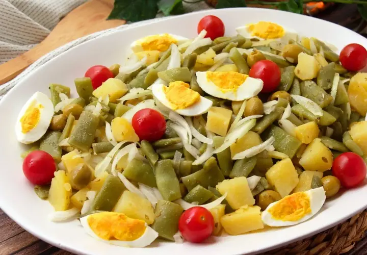Deliciosa ensalada de judías verdes con patatas, huevo duro, tomates cherry y aceitunas. Un plato fresco y nutritivo.