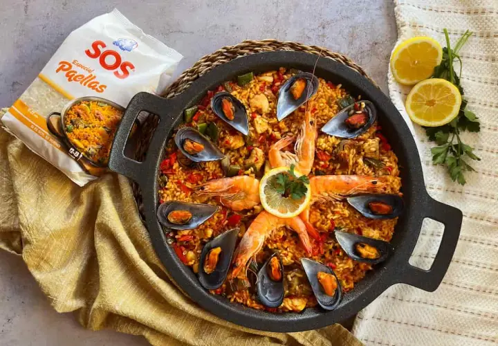 Paella mixta con gambas, mejillones y arroz dorado, lista para disfrutar.