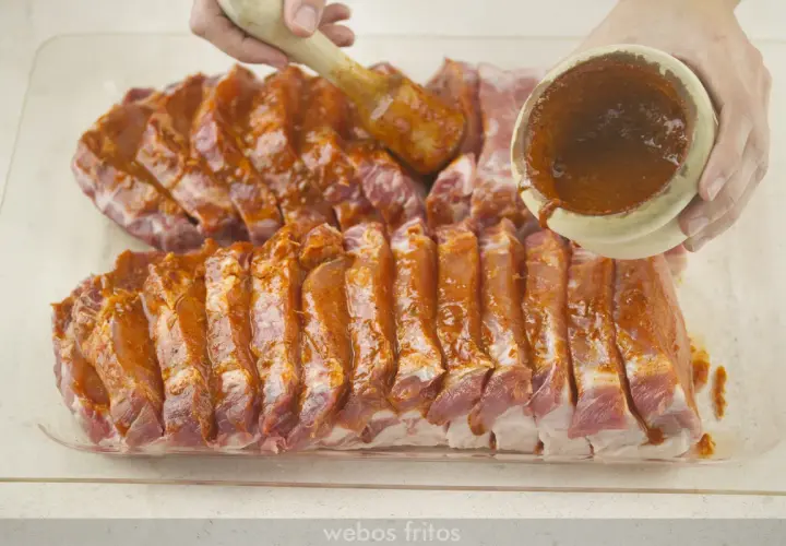 Costillas de lomo adobado listas para cocinar, cubiertas con una sabrosa marinada roja.