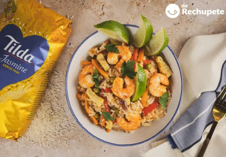 Delicioso arroz con langostinos, zanahoria, guisantes y pimiento rojo, decorado con lima y perejil. ¡Un plato para chuparse los dedos!