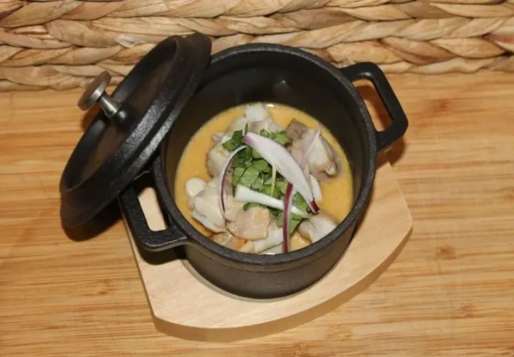 Delicioso ceviche de corvina, fresco y con un toque de cebolla morada y cilantro, servido en una cazuela de hierro fundido.