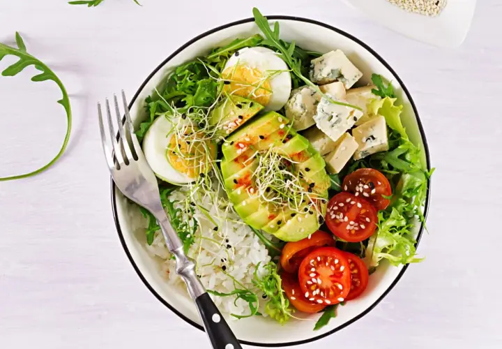 Deliciosa ensalada de aguacate con huevo cocido, queso azul, tomates cherry, brotes y arroz blanco.