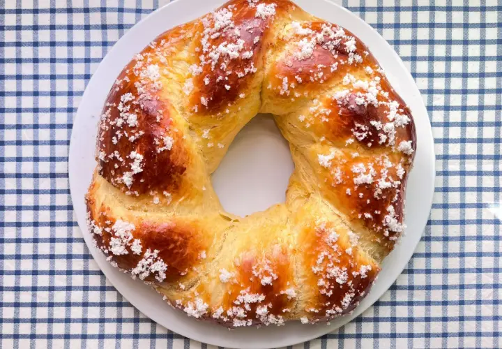 Rosca de Pascua dorada y brillante, espolvoreada con azúcar, lista para compartir en familia.