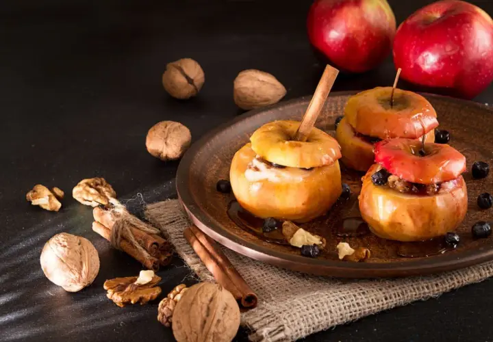 Deliciosas manzanas al horno con canela, nueces y arándanos, un postre casero perfecto.