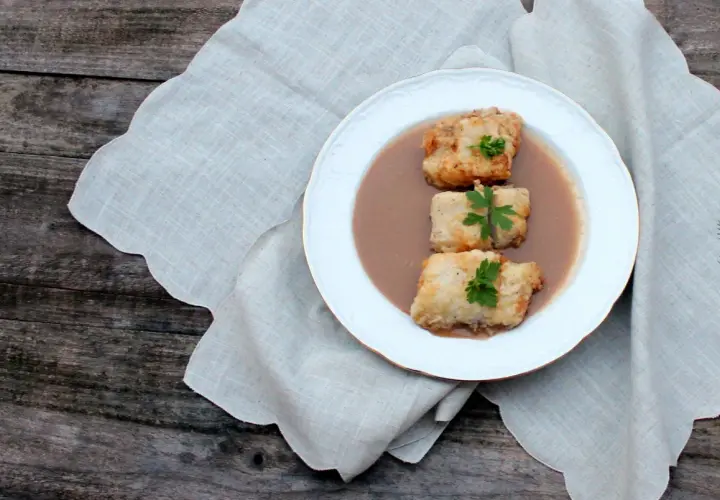 Tres trozos de bacalao rebozado en una salsa cremosa, decorados con perejil. Una de las muchas deliciosas recetas de bacalao.