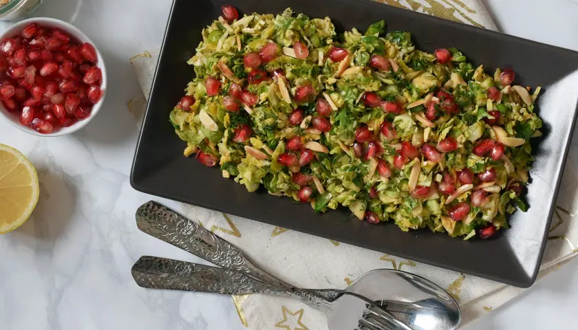 Ensalada de col con granada y almendras laminadas, un plato fresco y vibrante.