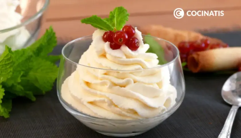 Deliciosa nata montada en copa, coronada con grosellas rojas y menta. Perfecta para cualquier postre.