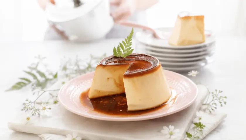 Delicioso flan de queso con caramelo líquido, decorado con una ramita verde.