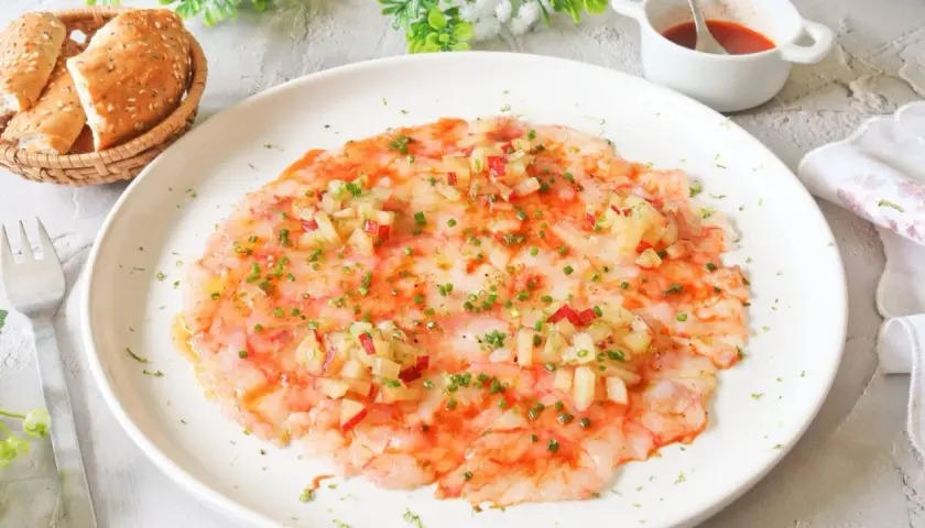 Delicioso carpaccio de gamba roja, finas láminas de gamba cruda con aderezo y picadillo de verduras.