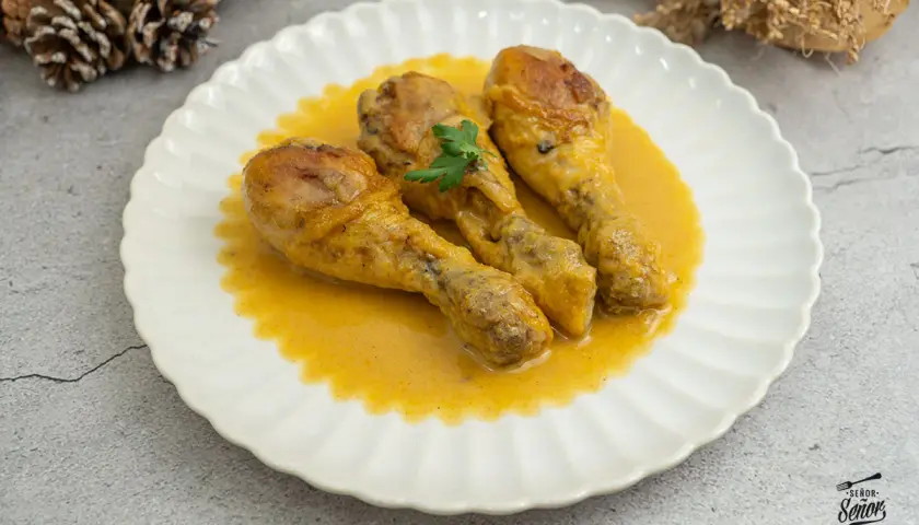 Tres jamoncitos de pollo en una cremosa salsa amarilla, decorados con perejil. ¡Un plato casero delicioso!