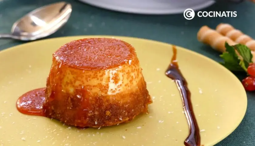 Delicioso flan de coco con caramelo líquido y coco rallado, servido en un plato amarillo.