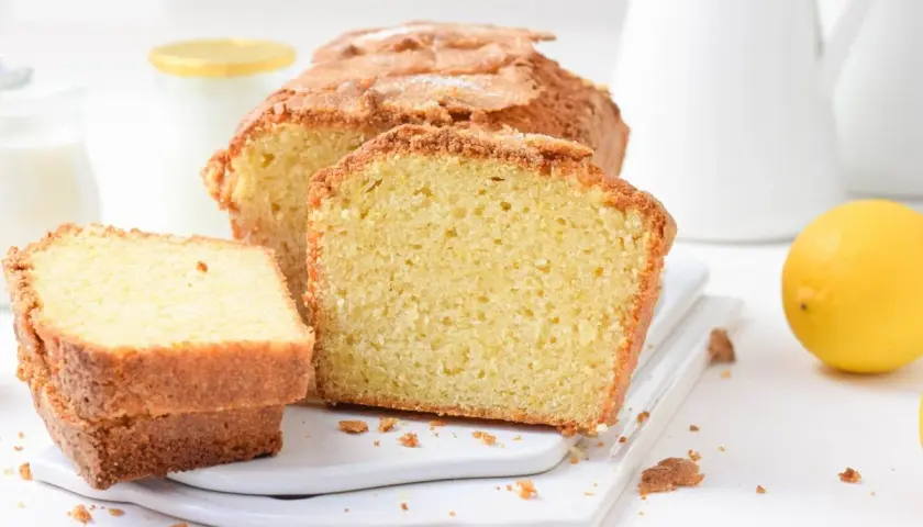 Bizcocho de limón esponjoso, perfecto para tu próxima receta. Con un limón fresco y una jarra de leche al fondo.