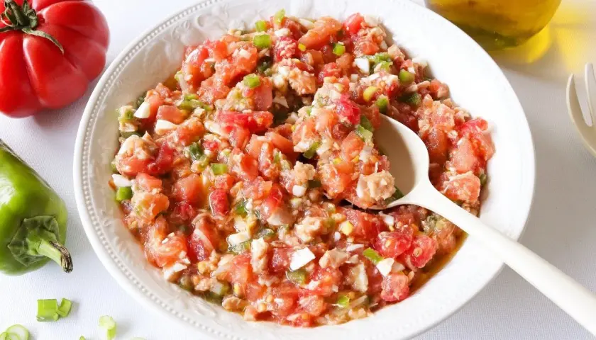Un plato de pipirrana de Jaén, una ensalada fresca de tomate, pimiento y huevo, lista para disfrutar.