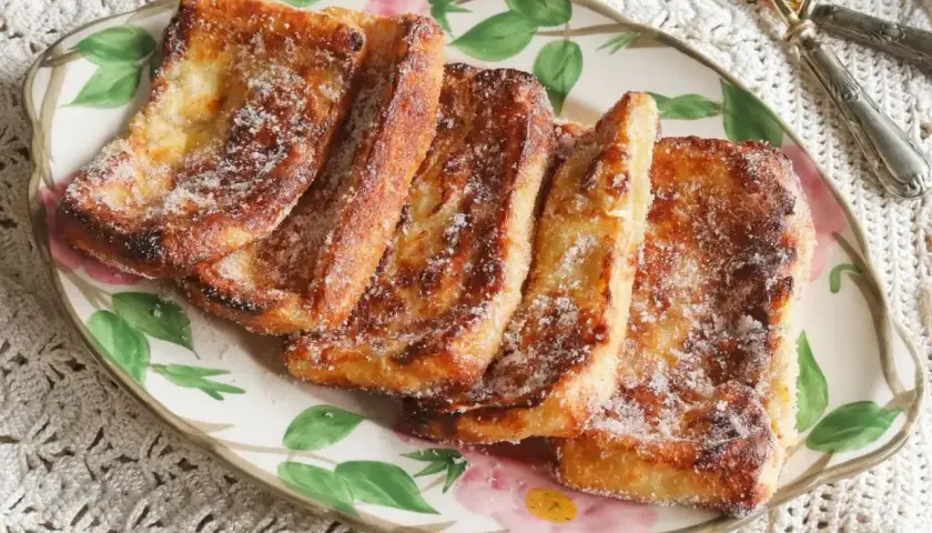Torrijas doradas y crujientes, espolvoreadas con azúcar, recién salidas de la freidora de aire. ¡Un placer casero!