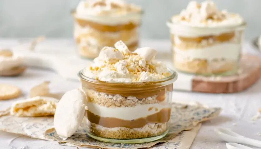 Postre en vaso con capas de galleta, crema y dulce de leche. Un toque de polvito uruguayo corona esta delicia.