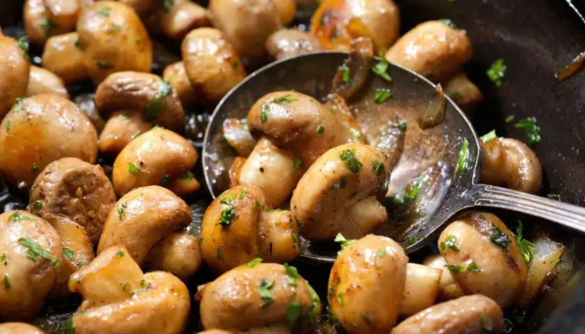 Champiñones salteados con perejil, listos para ser parte de deliciosas recetas con champiñones.