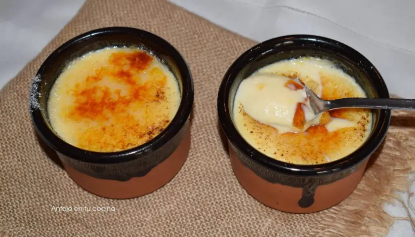 Dos deliciosas cremas catalanas, una con una cucharada lista para disfrutar, sobre una tela rústica.