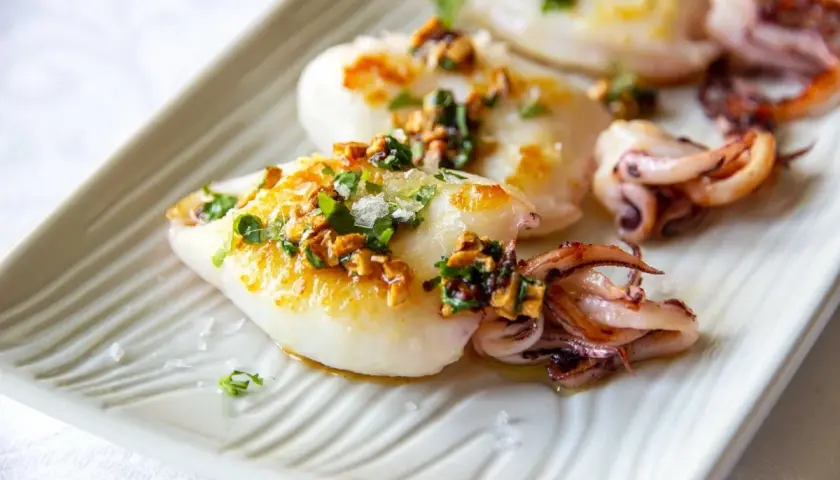 Chipirones a la plancha, tiernos y dorados, con un toque de ajo y perejil picado. Un plato sencillo y delicioso.