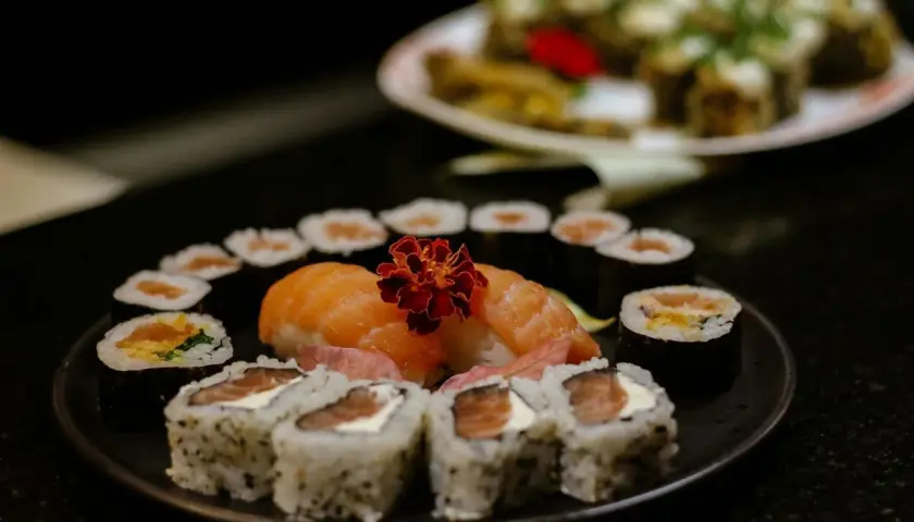 Delicioso arroz sushi receta con salmón fresco y flor decorativa. Un festín visual y culinario.