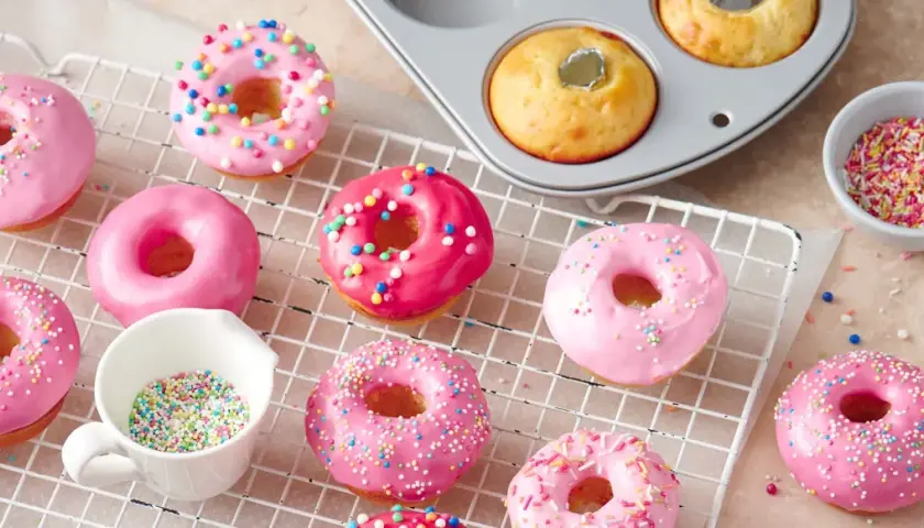 Deliciosos donuts rosados y brillantes, listos para decorar. Una tentadora receta de donuts para disfrutar.