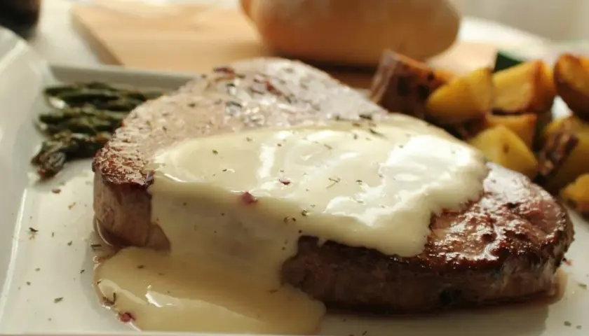 Jugoso redondo de ternera bañado en salsa cremosa, acompañado de espárragos y patatas asadas.